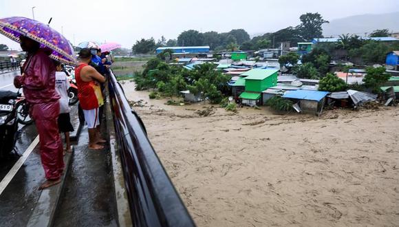 Las personas permanecen en lugares altos mientras las inundaciones arrasan una zona residencial en Dili, Timor Oriental. (EFE / EPA / ANTONIO DASIPARU).