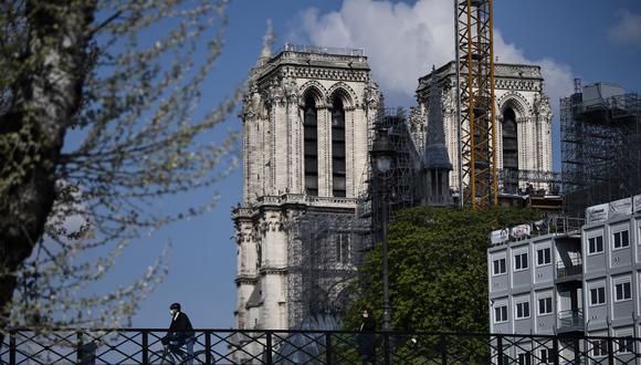 Un ciclista pasa sobre el Puente del Arzobispo, cerca de la catedral de Notre Dame de París, Francia, el 14 de abril de 2021. (Anne-Christine POUJOULAT / AFP).