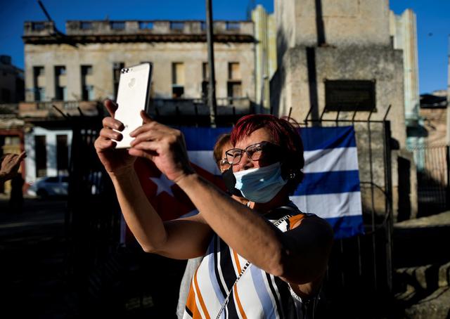 Una mujer simpatizante del presidente cubano Miguel Díaz-Canel, participan en un concierto de concentración para condenar la supuesta campaña mediática en apoyo al movimiento San Isidro. (YAMIL LAGE / AFP).