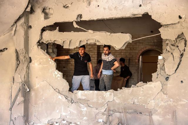 Los palestinos revisan los daños causados ​​por un ataque aéreo israelí en el Banco Nacional Islámico del movimiento palestino Hamas en Khan Yunis, en el sur de la Franja de Gaza. (Foto de SAID KHATIB / AFP).