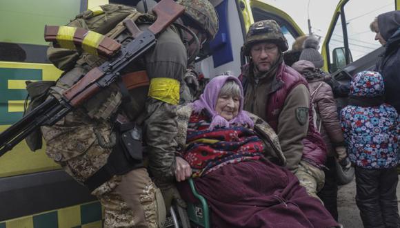 Residentes y militares ayudan a una anciana a huir de la ciudad de primera línea de Irpin, región de Kiev (Kiev), Ucrania. (Foto: EFE/EPA/STRINGER).