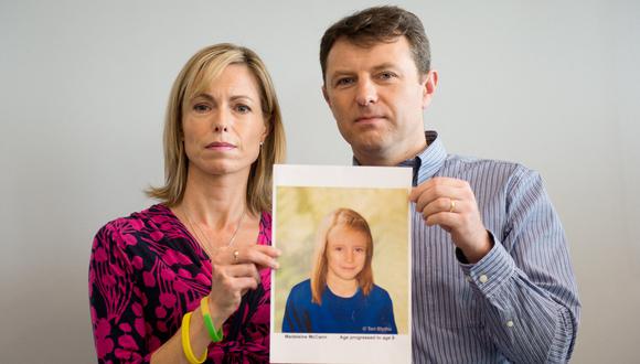 Los padres de la niña desaparecida Madeleine McCann, Kate y Gerry McCann, posan con una representación artística de cómo se vería su hija, el 2 de mayo de 2012. (Foto de LEON NEAL / AFP).