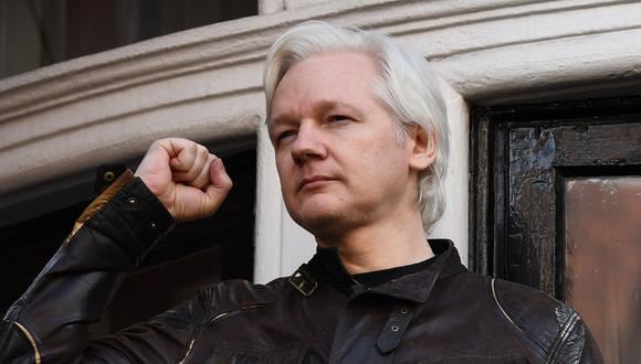 El fundador de Wikileaks, Julian Assange, levanta el puño antes de dirigirse a los medios de comunicación en el balcón de la Embajada de Ecuador en Londres el 19 de mayo de 2017. (Foto de Justin TALLIS / AFP).