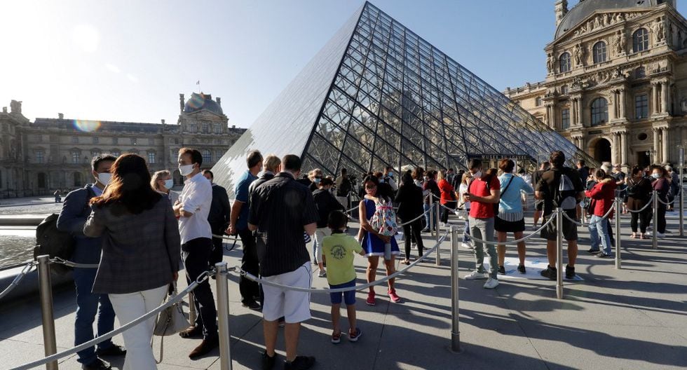 La gente hace cola en la pirámide del Louvre diseñada por el arquitecto chino Leoh Ming Pei, la entrada al Museo del Louvre en París. (Photo by FRANCOIS GUILLOT / AFP)