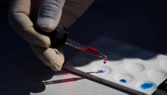 Un especialista del Instituto Nacional de Ciencias Forenses (Inacif), realiza pruebas de pureza a un paquete de cocaína durante un operativo. (Foto referencial: EFE)