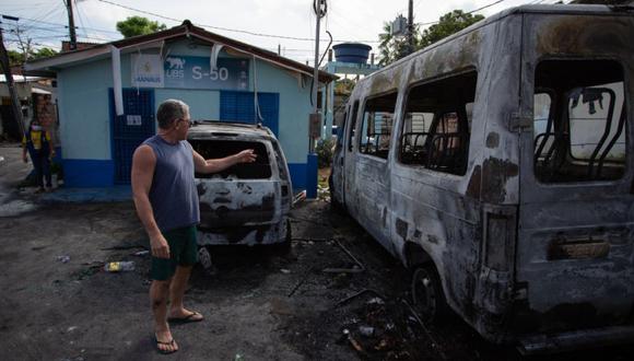 Un hombre mira vehículos quemados tras un ataque de narcotraficantes tras la muerte de uno de sus asociados en Manaos, estado de Amazonas, Brasil. (Foto: MICHAEL DANTAS / AFP).