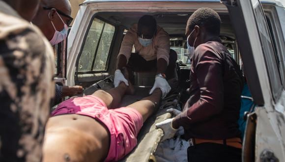 Personas levantan un cadáver encontrado en las calles de Petion-ville, en Puerto Príncipe, Haití, el 20 de marzo de 2024. (Foto de Mentor David Lorens / EFE)