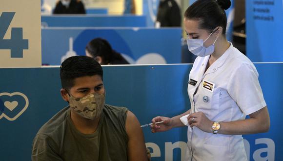 Un miembro de las Fuerzas Armadas está siendo inoculado contra el coronavirus con la vacuna AstraZeneca/Oxford, en el Centro Cultural CCK en Buenos Aires el 15 de junio de 2021. (Foto de Juan MABROMATA / AFP)