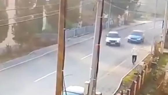 El dramático momento en el que un hombre casi es atropellado por dos autos que chocaron en la pista | Captura de video YouTube / RT en español