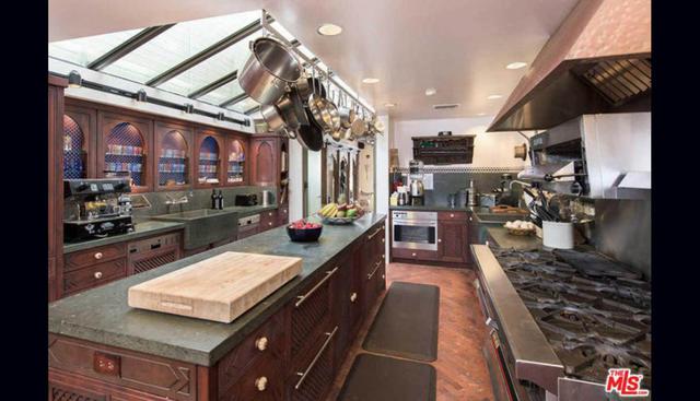 Superficies de hierro, mobiliario de madera oscura y piso de terracota conforman la decoración de la cocina. (Foto: MLS)