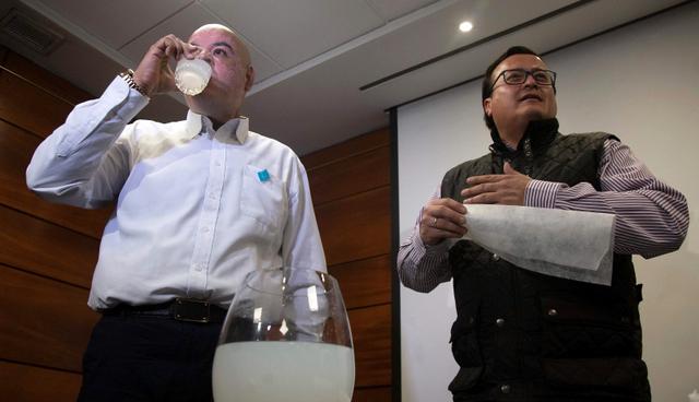Y para demostrar que el agua turbia que queda es "inocua" y sigue siendo potable, se bebe unos cuantos vasos de agua. (Foto: AFP/Claudio Reyes)