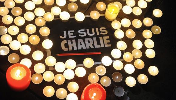 Esta foto de archivo tomada el 7 de enero de 2015 muestra velas colocadas junto a un letrero que dice 'Je suis Charlie' (Yo soy Charlie), y un bolígrafo en La Rochelle mientras la gente se reunía para rendir homenaje a las personas muertas en el ataque. (Foto de Xavier LEOTY / AFP)