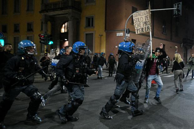 Riot police officers charge during skirmishes as people protest against the so-called Green Pass in Milan on October 16, 2021. (Photo: Piero CRUCIATTI / AFP)