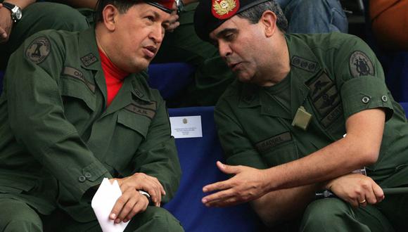 El presidente de Venezuela, Hugo Chávez (izq.), conversa con el ministro de Defensa, general Raúl Baduel, durante la ceremonia de toma de posesión del Comandante en Jefe del Ejército, el 11 de agosto de 2006. (FOTO AFP / Juan BARRETO).