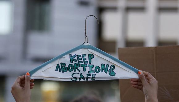 Una persona sostiene una percha de metal, con las palabras "Mantenga seguros los abortos" frente al Palacio de Justicia Federal Lloyd D. George en Las Vegas, Nevada, el 24 de junio de 2022. (Foto de Ronda Churchill / AFP)