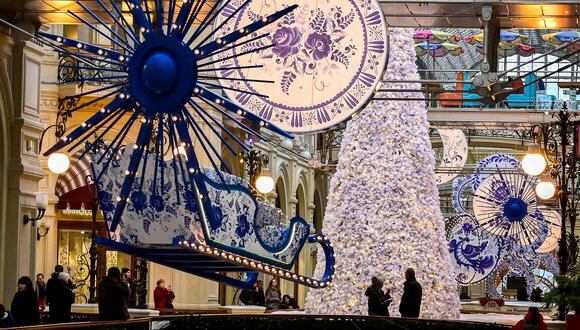 La gente mira las decoraciones de Navidad y Año Nuevo en los grandes almacenes GUM en la Plaza Roja de Moscú el 16 de noviembre de 2022. (Foto de Yuri KADOBNOV / AFP)
