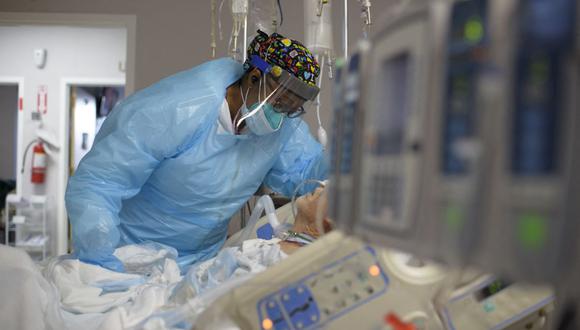 La trabajadora de atención médica Demetra Ransom consuela a un paciente en la sala Covid-19 del United Memorial Medical Center en Houston, Texas, el 4 de diciembre de 2020 (Foto de Mark Felix / AFP).