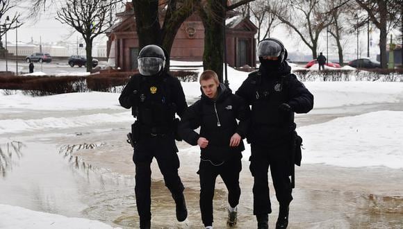 Agentes de policía detienen a un hombre mientras acudía al monumento para rendir tributo el difunto líder de la oposición rusa Alexei Navalny en San Petersburgo el 17 de febrero de 2024. (Foto de Olga MALTSEVA / AFP)
