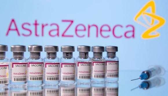 Los frascos etiquetados "Astra Zeneca COVID-19 Coronavirus Vaccine" y una jeringa se ven frente a un logotipo de AstraZeneca. (Foto: REUTERS / Dado Ruvic / Illustration).