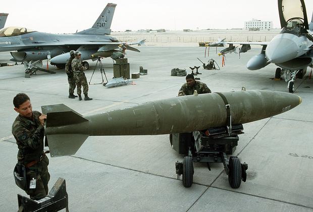 Miembros del 401 Escuadrón de Generación de Aeronaves se preparan para cargar bombas MARK 84 en el avión F-16 Fighting Falcon durante la Operación Tormenta del Desierto. (Dominio Público).