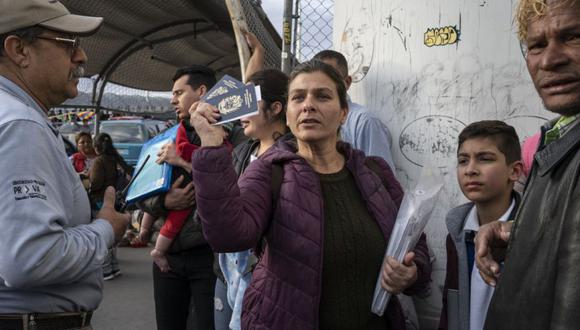Un ciudadana venezolana muestra pasaportes mientras las autoridades migratorias mexicanas intentan convencer a su grupo de que abandone el Puente Internacional Paso del Norte el 28 de febrero de 2020, en Ciudad Juárez. (Foto: archivo / Paul Ratje / AFP)