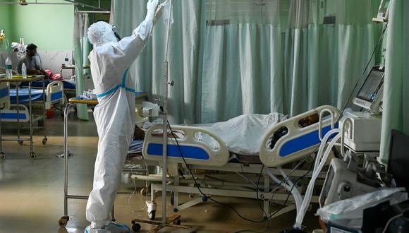 Un trabajador de la salud atiende a un paciente con Covid-19 dentro de una Unidad de Cuidados Intensivos (UCI) en la India. (Foto: Prakash SINGH / AFP)