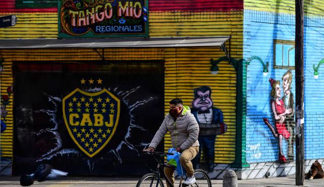 Un hombre monta su bicicleta en una calle vacía del barrio de La Boca en Buenos Aires, el 9 de julio de 2020, en medio de la pandemia de coronavirus.  (AFP / Ronaldo SCHEMIDT).