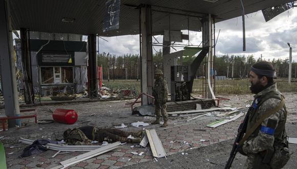 Militares ucranianos encuentran el cuerpo de un soldado ruso en la gasolinera destruida en la ciudad recientemente recuperada de Lyman, Ucrania, el lunes 3 de octubre de 2022. (Foto AP/Evgeniy Maloletka).