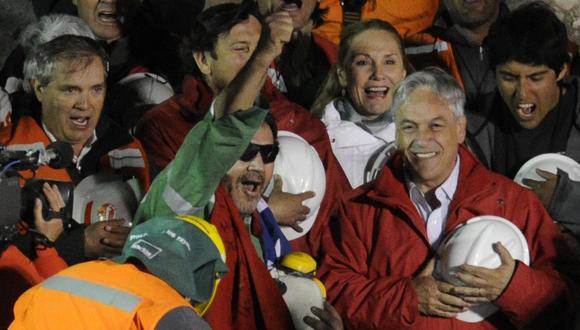 El último de los 33 mineros chilenos rescatados, Luis Urzúa (C), celebra junto al presidente de Chile Sebastián Piñera, el 13 de octubre de 2010. (Foto de JUAN MABROMATA/AFP).