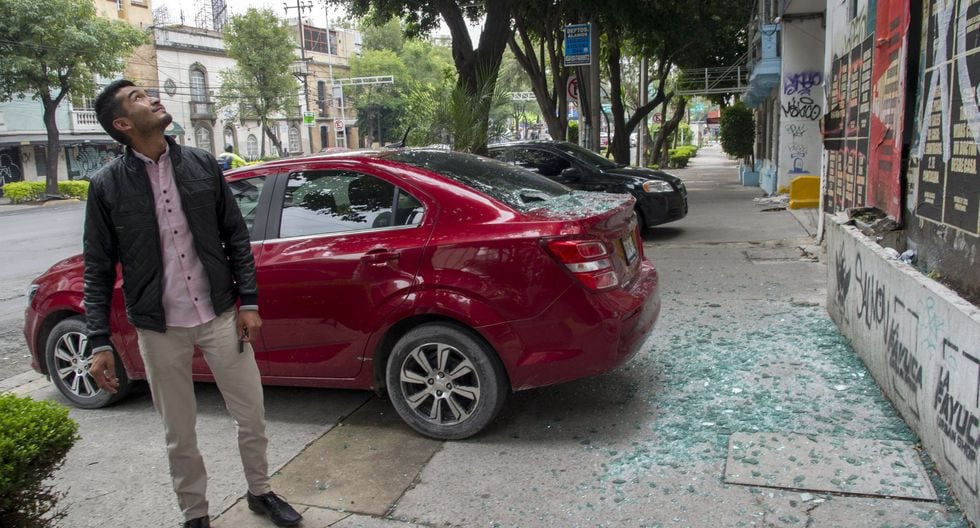 Un hombre mira un edificio después de que su automóvil fuera dañado por un vidrio roto y objetos que cayeron sobre él durante un terremoto en la Ciudad de México. (Foto por CLAUDIO CRUZ / AFP).