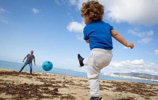 Un niño juega fútbol con su padre en la playa de Can Pere Antoni en Palma de Mallorca. Los menores pudieron salir a la calle en España luego de 6 semanas de cuarentena por coronavirus (AFP / JAIME REINA).