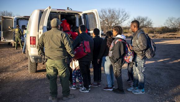 Un grupo de migrantes es procesado por la Patrulla Fronteriza después de cruzar el río ilegalmente cerca de la carretera el 4 de febrero de 2024 en las afueras de Eagle Pass, Texas. (Foto de SERGIO FLORES / AFP)