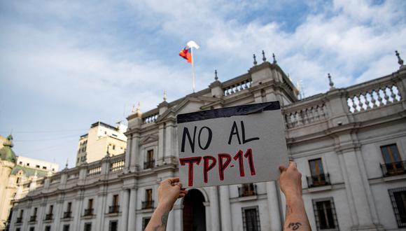 Activistas ambientales realizan una protesta contra el TTP-11 (Asociación Transpacífica) en los alrededores del palacio presidencial de La Moneda en Santiago, el 27 de septiembre de 2022.  (Foto por Martín BERNETTI / AFP)