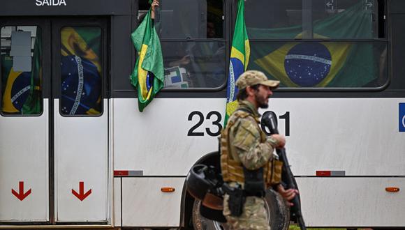 Partidarios detenidos del expresidente de extrema derecha de Brasil, Jair Bolsonaro, son llevados en autobuses por fuerzas policiales a la sede de la policía federal para verificar sus identidades. (MAURO PIMENTEL / AFP).
