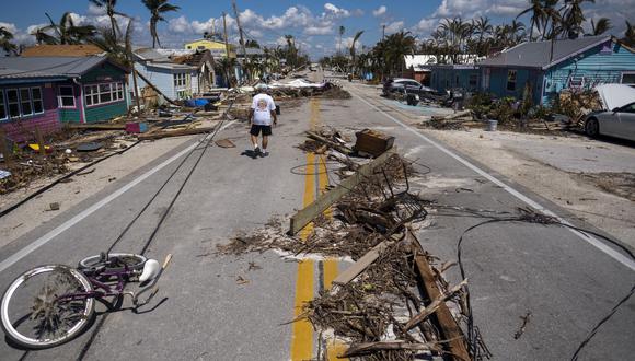 Un hombre camina junto a los escombros esparcidos en Pine Island Road después del huracán Ian en Matlacha, Florida, el 1 de octubre de 2022. (Foto de Ricardo ARDUENGO / AFP)
