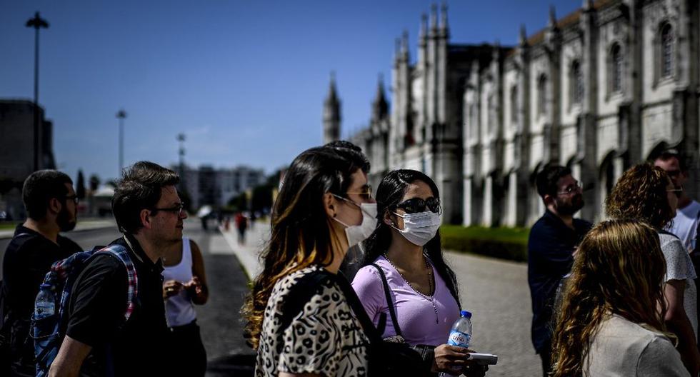Un grupo de turistas, que usan máscaras protectoras, hacen cola con otros para ingresar al Monasterio de los Jerónimos, en Lisboa. (AFP)