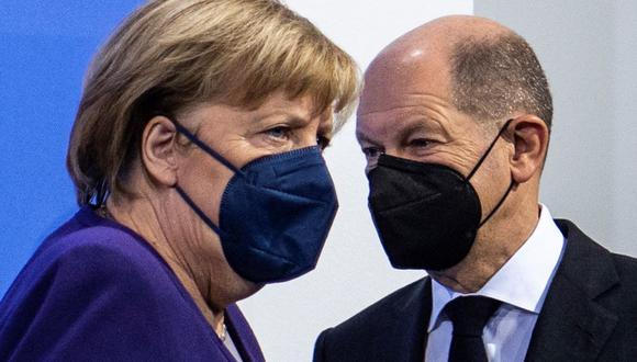 En esta foto del 2 de diciembre de 2021, la canciller alemana Angela Merkel y su sucesor Olaf Scholz llegan para una conferencia de prensa luego de una reunión con los jefes de gobierno de los estados federales. (JOHN MACDOUGALL / POOL / AFP).