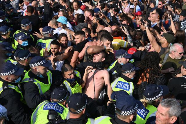 La policía carga contra los manifestantes antivacunas y las restricciones por coronavirus, incluido el uso de mascarillas, en Trafalgar Square. ( Foto de DANIEL LEAL-OLIVAS / AFP).