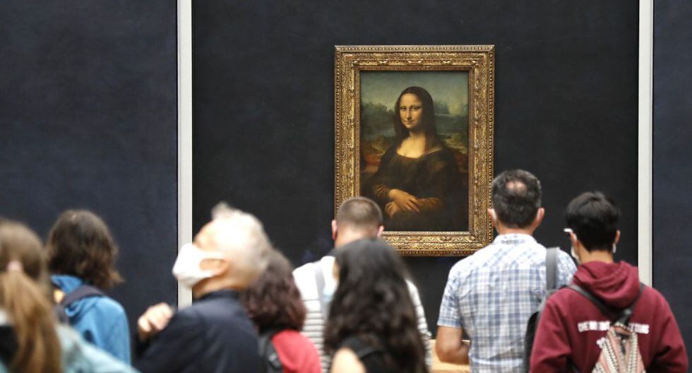 Los visitantes usan máscaras faciales mientras toman fotos frente a la obra maestra de Leonardo da Vinci, la "Mona Lisa", también conocida como "La Gioconda". El museo del Louvre reabrió sus puertas después de meses de cierre debido a medidas de cierre vinculadas a la pandemia de COVID-19. (FRANCOIS GUILLOT / AFP)