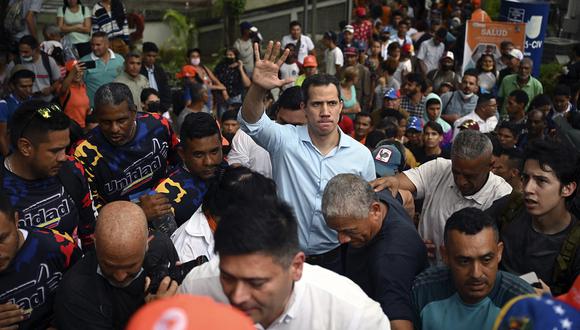 El líder de la oposición venezolana, Juan Guaidó, saluda durante una manifestación para exigir una fecha para las elecciones presidenciales en Caracas, el 27 de octubre de 2022. (Foto de Federico PARRA / AFP)
