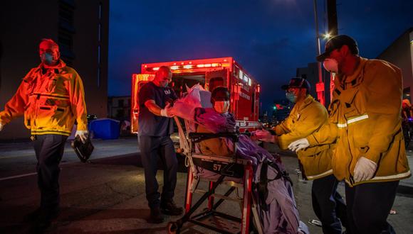 Imagen referencial. Los paramédicos asisten a una mujer sin hogar en medio de la pandemia de coronavirus en el centro de Los Ángeles, California, el 12 de abril de 2020. (Apu GOMES / AFP).