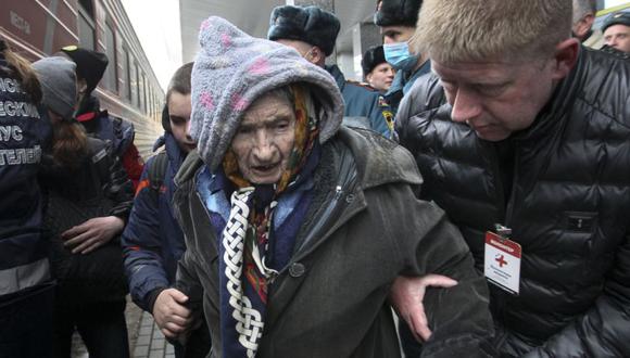 Los voluntarios ayudan a una anciana mientras personas de las regiones de Donetsk y Lugansk, dejan un tren para ser llevado a residencias temporales en la región de Nizhny Novgorod, en la estación de tren de Nizhny Novgorod, Rusia.