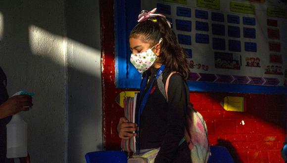 Una niña es desinfectada cuando ingresa a una escuela durante la reanudación de las clases presenciales en la Ciudad de México el 7 de junio de 2021. (Foto de CLAUDIO CRUZ / AFP).