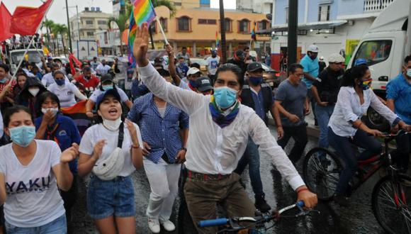 El candidato presidencial ecuatoriano por el movimiento Pachakutik, Yaku Pérez, saluda a sus simpatizantes mientras conduce su bicicleta durante el acto de clausura de su campaña el 1 de febrero de 2021. (Foto: AFP / JOSE SÁNCHEZ LINDAO Y JOSE SANCHEZ LINDAO).