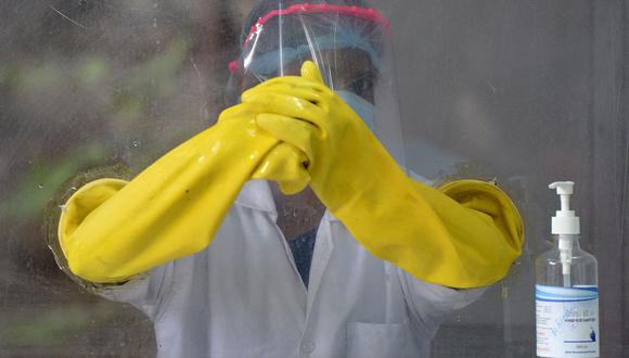 Un trabajador de la salud espera para recolectar muestras de hisopos con el fin de realizar la prueba del coronavirus Covid-19 en un centro de recolección de muestras en Hyderabad el 19 de octubre de 2020 (Foto de NOAH SEELAM / AFP).