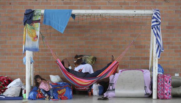 En esta foto del 26 de marzo de 2021, desplazados venezolanos descansan bajo una portería de fútbol en un refugio instalado en un centro comunitario en Arauquita, Colombia, en la frontera con Venezuela. Los venezolanos buscan refugio en Colombia esta semana luego de los enfrentamientos entre el ejército de Venezuela y un grupo armado colombiano. (Foto AP/Fernando Vergara)