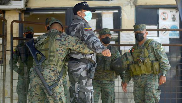 Soldados registran a un policía en la entrada de una prisión en Guayaquil, Ecuador, el 29 de septiembre de 2021. (Fernando MENDEZ / AFP).