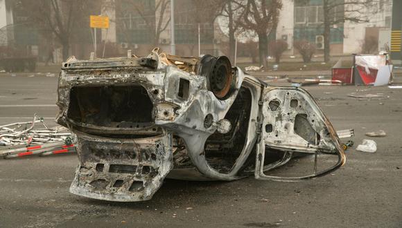 un automóvil quemado en una plaza cerca de un barrio administrativo en el centro de Almaty, kazajistán, el 6 de enero de 2022. (Alexander BOGDANOV / AFP).