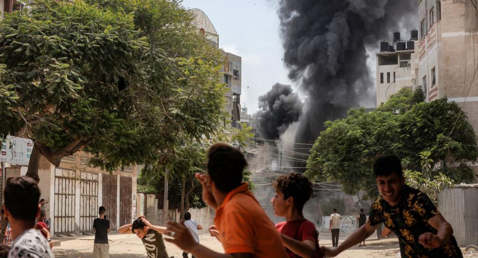La gente corre para ponerse a cubierto durante el bombardeo aéreo de Israel en la ciudad de Gaza el 6 de agosto de 2022. (ANAS BABA / AFP).