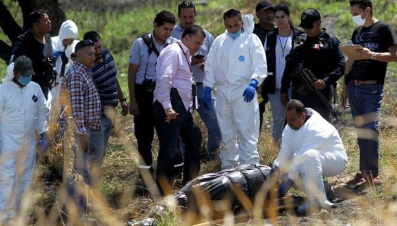 Expertos forenses trabajan en la recuperación de, al menos, 10 cuerpos envueltos en bolsas encontradas en un cauce de aguas negras en la carretera La Capilla en Ixtlahuacan de los Membrillos, estado de Jalisco. (Foto: AFP)